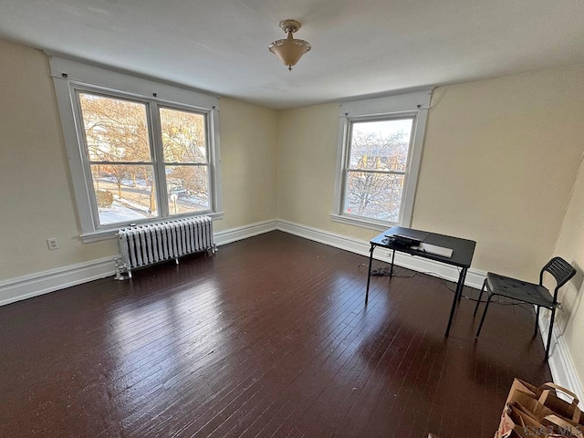 unfurnished room featuring radiator and dark hardwood / wood-style floors