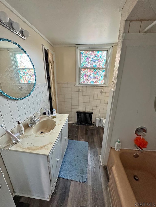 full bathroom with hardwood / wood-style flooring, tub / shower combination, tile walls, vanity, and toilet