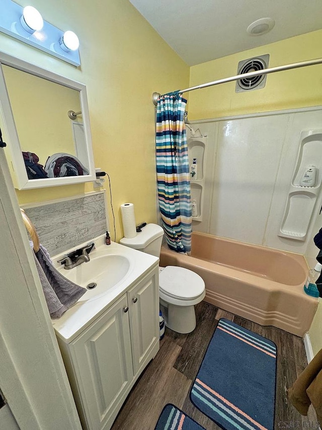 full bathroom featuring wood-type flooring, toilet, shower / tub combo with curtain, and vanity