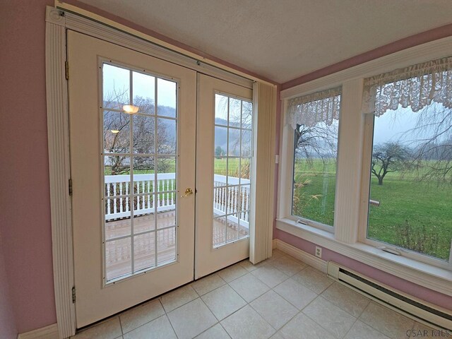 entryway with french doors, light tile patterned floors, and a baseboard heating unit