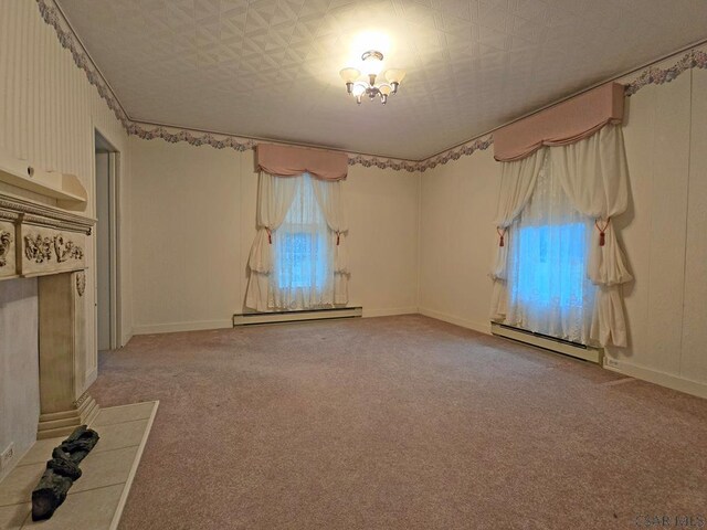 carpeted empty room featuring a baseboard radiator and a wealth of natural light