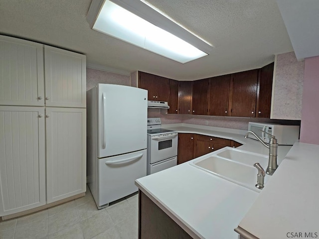 kitchen featuring sink, white appliances, dark brown cabinets, and kitchen peninsula