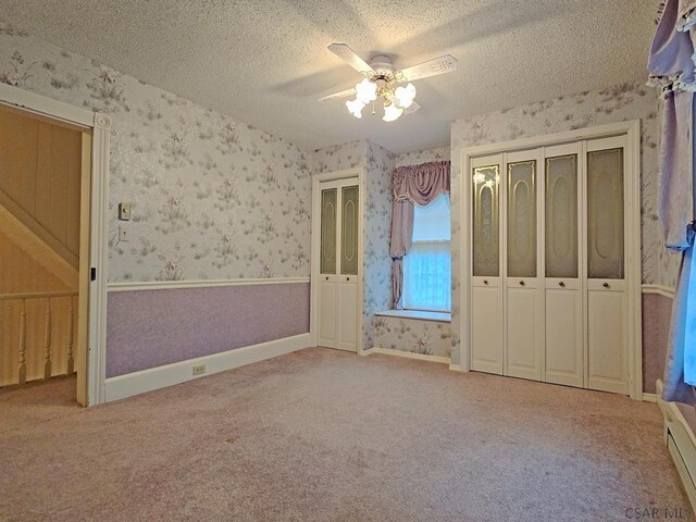 unfurnished bedroom featuring a textured ceiling, carpet floors, and ceiling fan