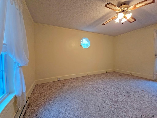 carpeted spare room featuring crown molding, ceiling fan, and a textured ceiling