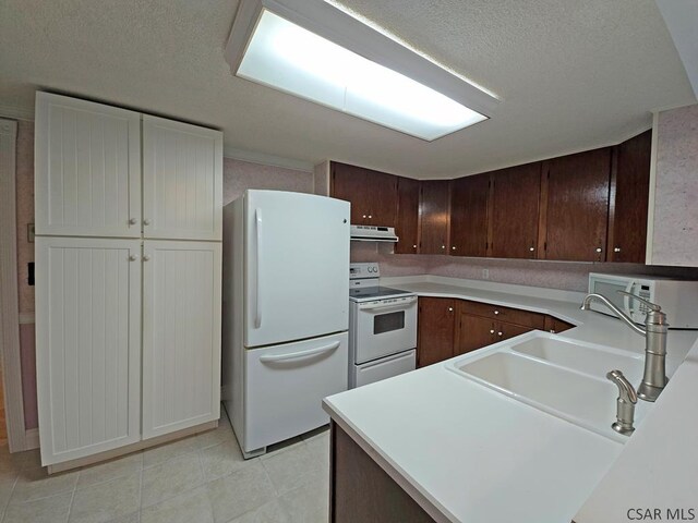 kitchen featuring white appliances, sink, dark brown cabinets, and a textured ceiling