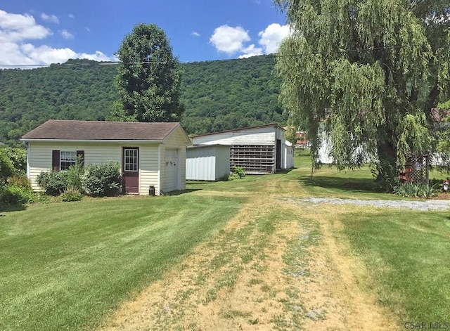 view of yard with a garage, an outbuilding, and a mountain view