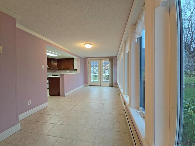 interior space with a baseboard radiator, dishwasher, ornamental molding, dark brown cabinetry, and french doors