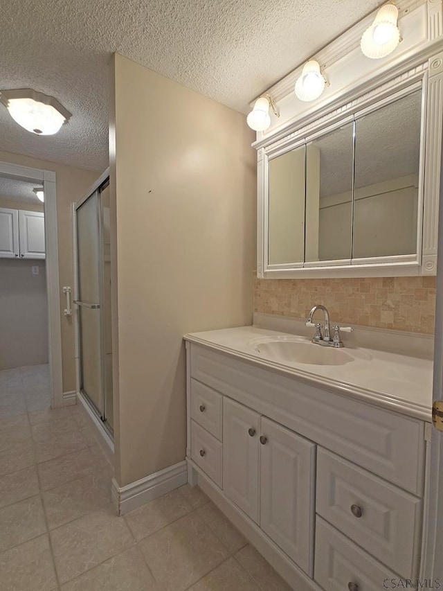 bathroom featuring vanity, tile patterned flooring, a textured ceiling, and walk in shower