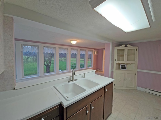 kitchen featuring a baseboard radiator, sink, a textured ceiling, and dark brown cabinetry