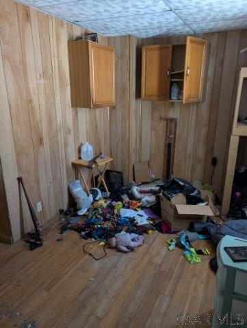 miscellaneous room with hardwood / wood-style floors, wooden walls, and a textured ceiling