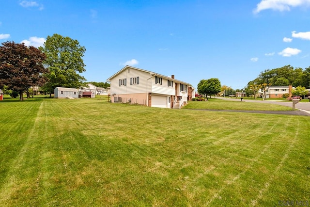 129 Berkey Dr, Johnstown, PA 15904 - view of grassy yard featuring an attached garage and central AC unit