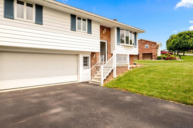 129 Berkey Dr, Johnstown, PA 15904 - bi-level home with brick siding, a front lawn, an attached garage, and asphalt driveway