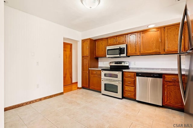 129 Berkey Dr, Johnstown, PA 15904 - kitchen with appliances with stainless steel finishes, brown cabinetry, light countertops, and baseboards