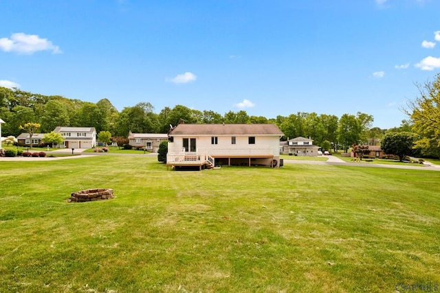 129 Berkey Dr, Johnstown, PA 15904 - rear view of house featuring an outdoor fire pit, a wooden deck, a lawn, and view of wooded area