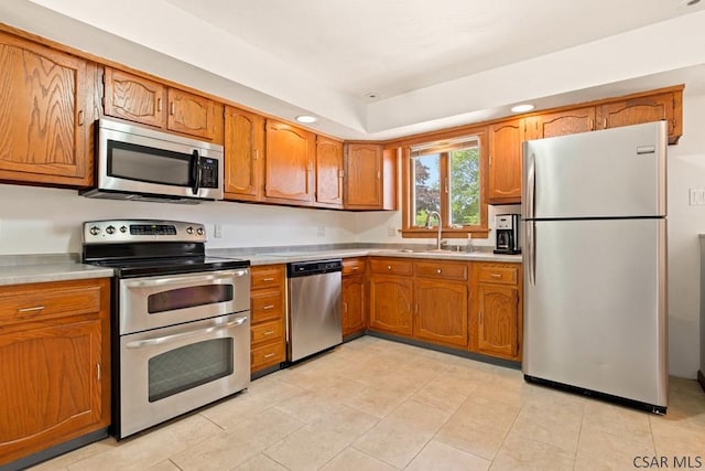 129 Berkey Dr, Johnstown, PA 15904 - kitchen featuring stainless steel appliances, a sink, brown cabinets, light countertops, and recessed lighting