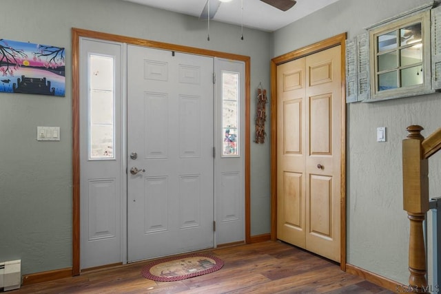 entrance foyer featuring a baseboard heating unit, dark wood-type flooring, and ceiling fan