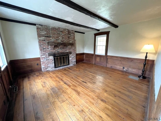 328 Thatcher Rd, New Florence, PA 15944 - unfurnished living room featuring a wainscoted wall, wood-type flooring, beamed ceiling, wooden walls, and a fireplace
