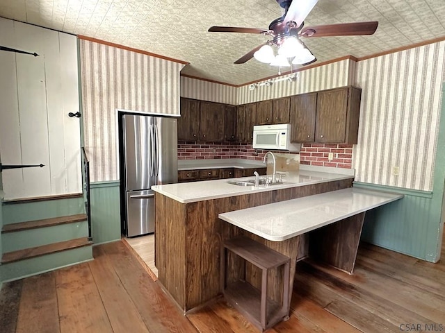 328 Thatcher Rd, New Florence, PA 15944 - kitchen with white microwave, freestanding refrigerator, an ornate ceiling, light wood-style flooring, and a peninsula