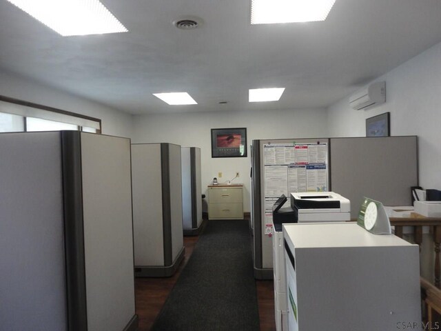 kitchen featuring dark wood finished floors, visible vents, a wall mounted AC, and freestanding refrigerator