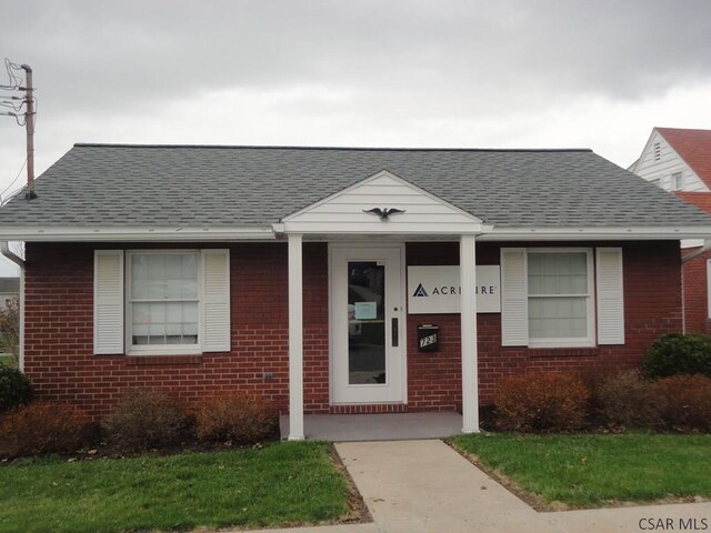 bungalow with brick siding and a shingled roof