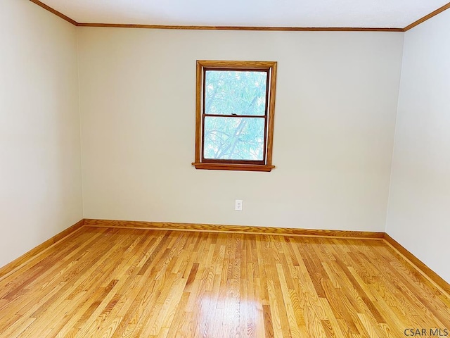 spare room featuring crown molding and light wood-type flooring