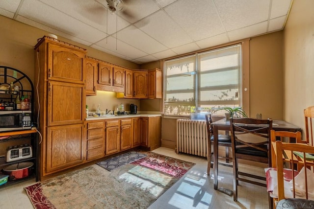 kitchen featuring a paneled ceiling and radiator heating unit