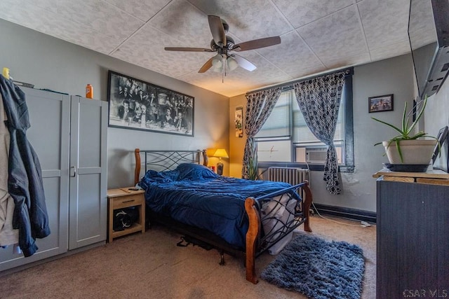 bedroom with cooling unit, ceiling fan, radiator heating unit, and carpet