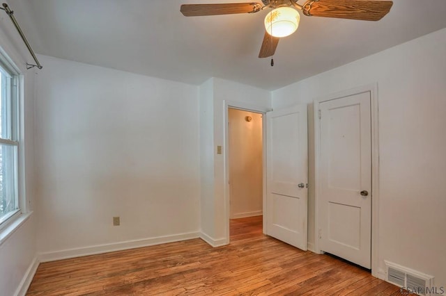 unfurnished bedroom with multiple windows, ceiling fan, and light hardwood / wood-style flooring