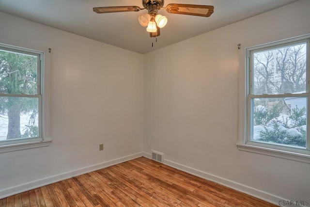 spare room with plenty of natural light, light hardwood / wood-style floors, and ceiling fan