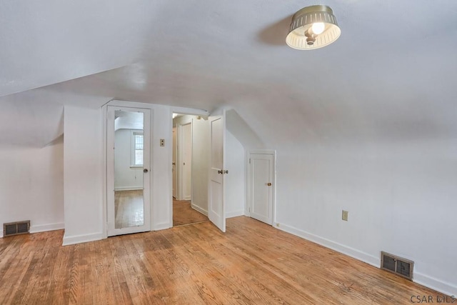 additional living space with lofted ceiling and light hardwood / wood-style floors