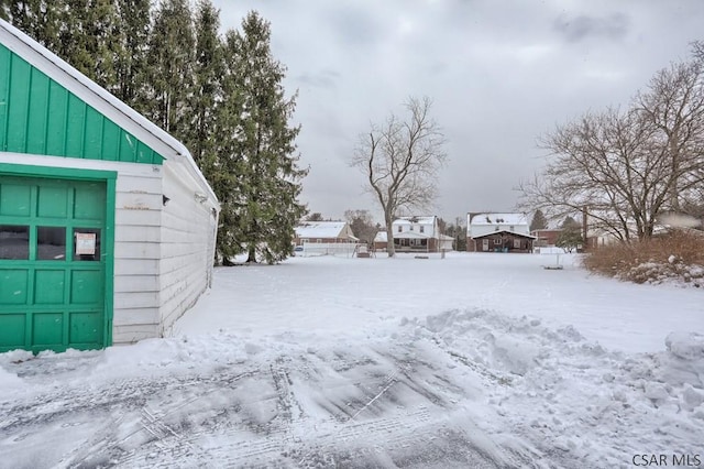 snowy yard with a garage