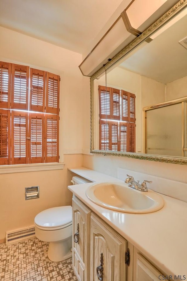 bathroom with vanity, an enclosed shower, and toilet