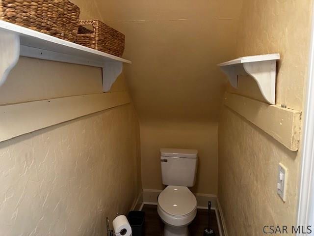 bathroom featuring baseboards and toilet