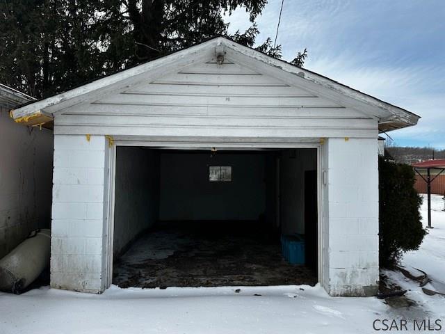 snow covered garage featuring a detached garage