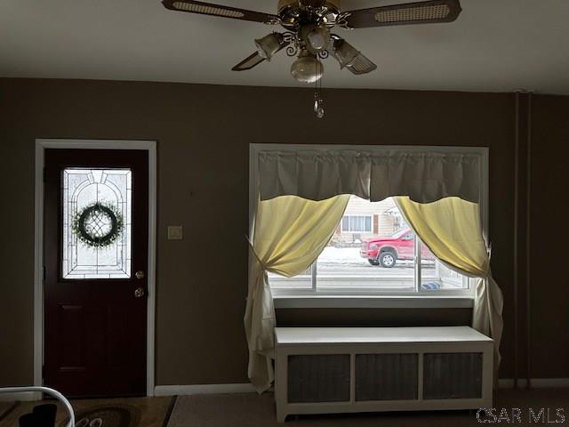 foyer entrance featuring ceiling fan, baseboards, and radiator