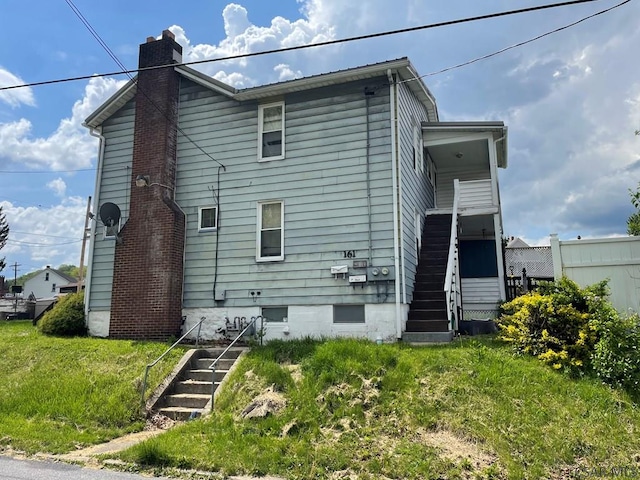 161 Stone St, Johnstown, PA 15906 - back of house featuring a chimney, stairs, and a yard