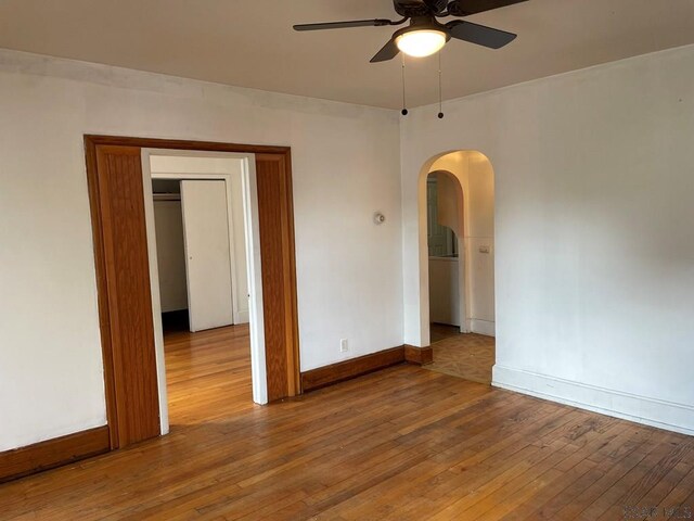 161 Stone St, Johnstown, PA 15906 - empty room with arched walkways, ceiling fan, hardwood / wood-style floors, and baseboards