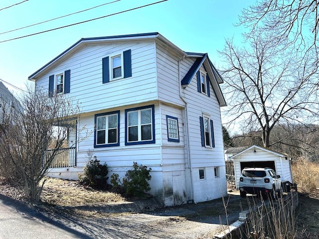 view of front of home featuring a garage, an outbuilding, and driveway