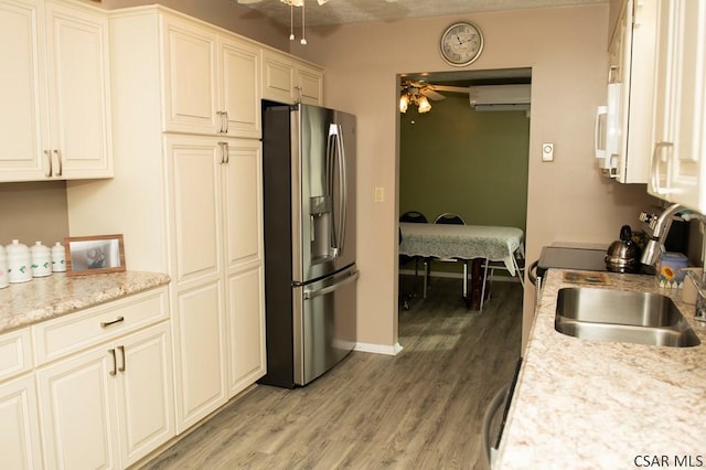 kitchen featuring sink, stainless steel fridge, ceiling fan, and light hardwood / wood-style floors