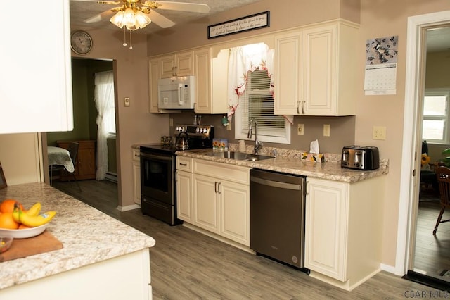 kitchen featuring white cabinets, sink, dishwashing machine, and stainless steel range with electric stovetop