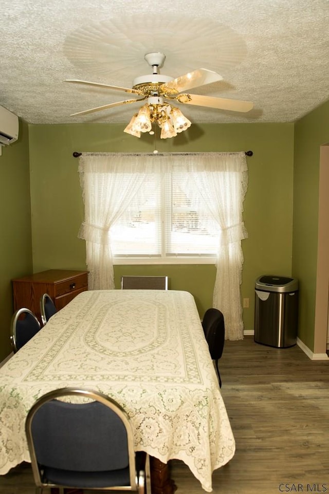 bedroom featuring wood-type flooring, a wall mounted AC, ceiling fan, and a textured ceiling