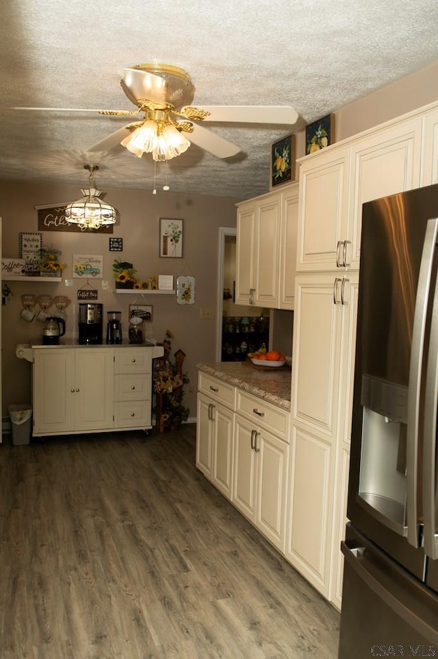 kitchen featuring a textured ceiling, dark hardwood / wood-style floors, stainless steel fridge, pendant lighting, and ceiling fan