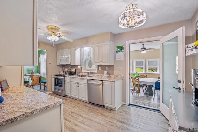 3313 Berlin Plank Rd, Berlin, PA 15530 - kitchen with white cabinets, stainless steel appliances, a textured ceiling, and ceiling fan with notable chandelier