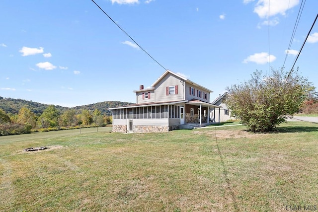 rear view of property with a yard and a sunroom