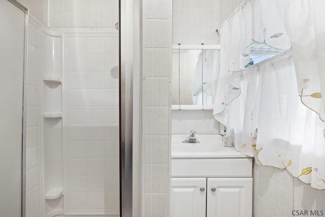 bathroom featuring vanity and a shower with door