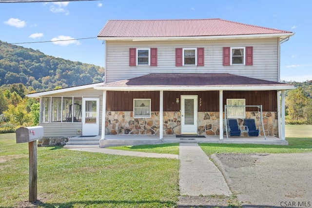 country-style home with a front yard, a sunroom, and a porch