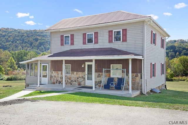 view of front of house featuring a front lawn and a sunroom