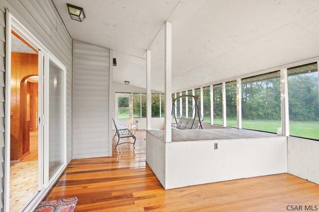 unfurnished sunroom with lofted ceiling