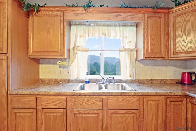 kitchen featuring a mountain view, sink, and decorative backsplash