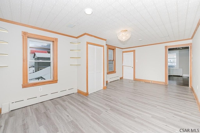 spare room featuring baseboards, ornamental molding, wood finished floors, baseboard heating, and a baseboard heating unit